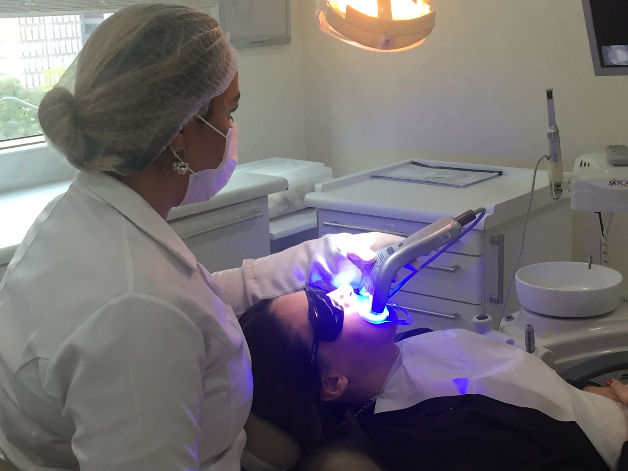 Atendimento odontológico com luz de fotopolimerização